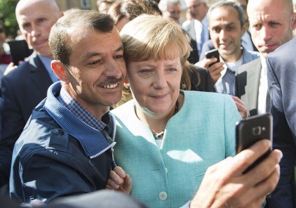 Người tị nạn chụp ảnh selfie với Thủ tướng Đức Angela Merkel trong chuyến thăm trung tâm dành cho những người tị nạn mới đến Berlin - Sputnik Việt Nam