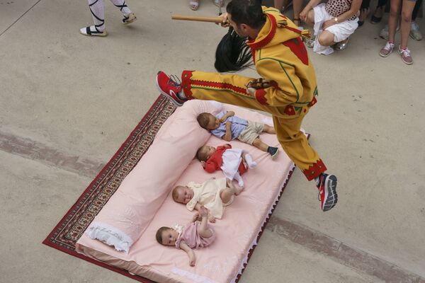 Người đàn ông mặc trang phục ma quỷ nhảy qua các em bé trong lễ hội hàng năm El Colacho ở thành phố Castillo de Murcia, Tây Ban Nha - Sputnik Việt Nam