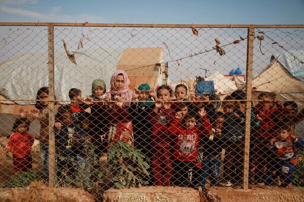 Trẻ em Syria cạnh hàng rào khu trại gần làng Kafr Lusin, Syria - Sputnik Việt Nam