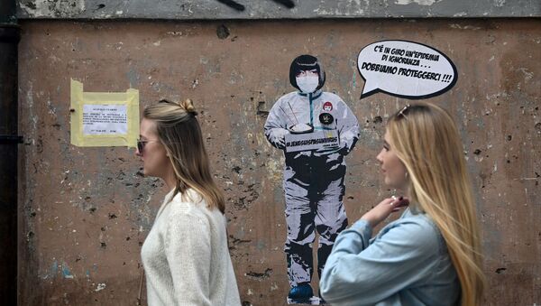Các cô gái trên nền của một bức tường với graffiti về chủ đề coronavirus của nghệ sĩ Laika ở Rome - Sputnik Việt Nam